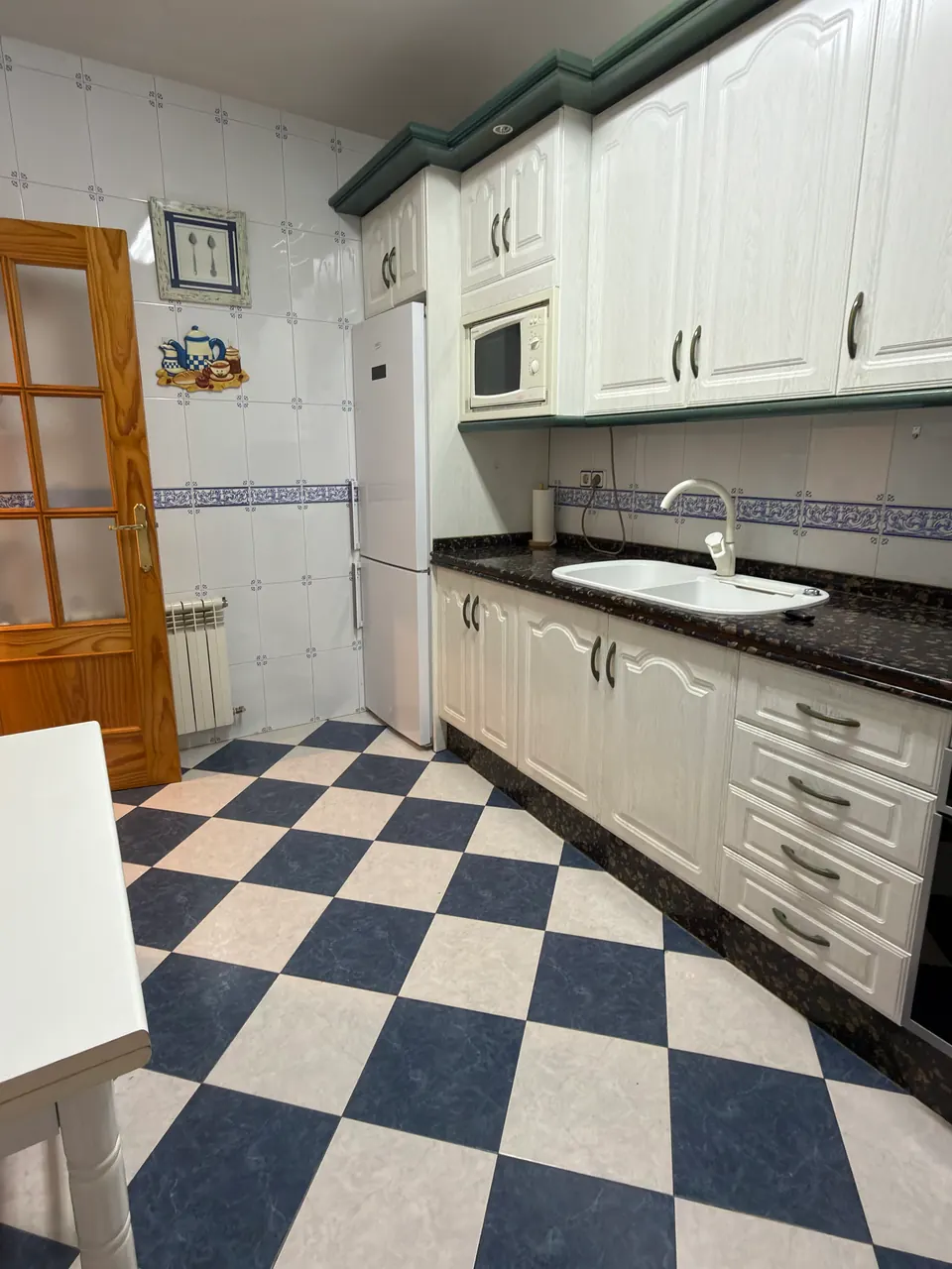 Cocina equipada con frigorífico combi, microondas y fregadero doble